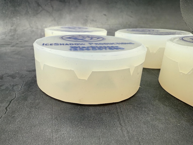 Op de afbeelding: Vier doorzichtige plastic containers met een wit, ondoorzichtig deksel. De deksels hebben een blauw logo met de tekst "ICESHADOW PRODUCTIONS" en daaronder de tekst "Blackbrier 1234567890".