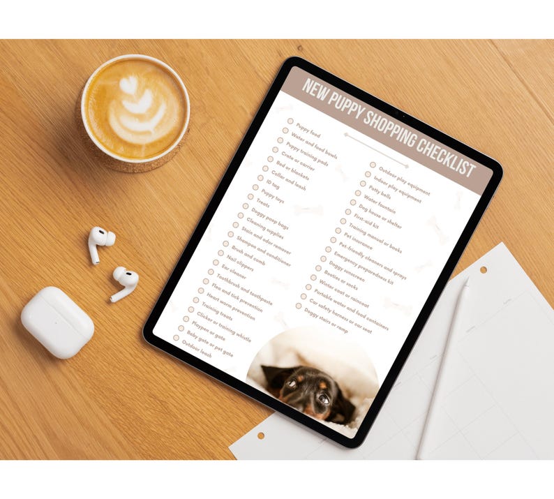 May include: A checklist on a tablet with the title "New Puppy Shopping Checklist". The checklist includes items such as puppy food, training pads, bed and blankets, collar and leash, toys, puppy play equipment, and more. A cute puppy is peeking out from under a blanket in the bottom right corner of the image.