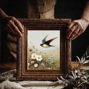 Puede incluir: Una taza de cerámica blanca con un asa negra y el texto "But First, Coffee" en negrita negra. La taza se encuentra sobre un fondo borroso, sugiriendo un ambiente acogedor.