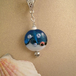 Handmade lampwork ocean sand blue wave necklace with glass raised sea urchin animals and small cats eye bead.