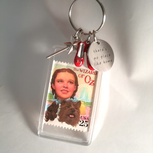 Wizard of Oz vintage unused stamp key chain from the 1990s with red shoe, magic wand, and No place like home text charm on key chain clasp