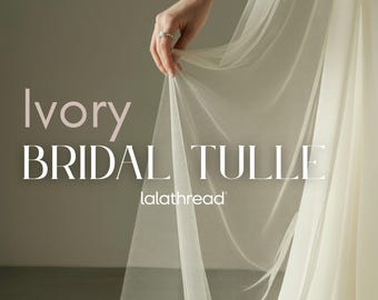 May include: Ivory bridal tulle fabric, held by a hand, with the text "Ivory BRIDAL TULLE" and "lalathread". The fabric is 65 inches wide and available in 23 colors. Soft tulle by the yard.