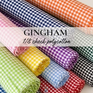 Puede incluir: Rollos de tela de cuadros vichy en varios colores: naranja, azul marino, rosa, verde, amarillo, morado, azul claro, rojo y negro. La tela es de poli&eacute;ster y algod&oacute;n a cuadros de 1/8, con el texto "GINGHAM 1/8 check polycotton".