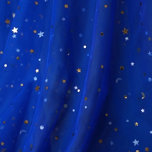 May include: Royal blue tulle fabric with gold star and dot sequins. The fabric has a delicate, sheer appearance, with the text "lalathread" in the upper right corner. Ideal for crafting projects, costumes, or decorative purposes.