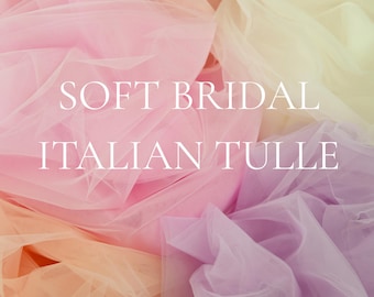 May include: A display of soft, colorful bridal tulle fabric in shades of pink, peach, and lavender. The text "SOFT BRIDAL ITALIAN TULLE" is overlaid on the fabric. The image also includes the text "23 colors • soft tulle by the yard • 65" wide".
