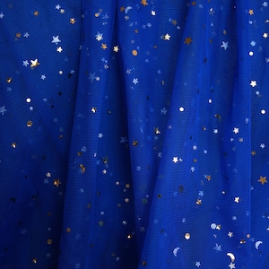 May include: Royal blue tulle fabric with gold star and dot embellishments. The fabric is draped, creating soft folds. The text "lalathread" is visible in the upper right corner. This fabric is suitable for crafting and apparel.