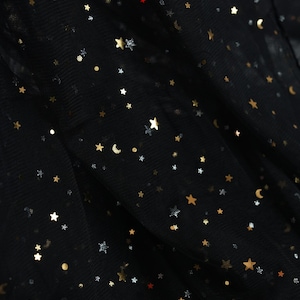 May include: Black fabric with gold and silver star and moon embellishments. The fabric has a sheer, layered appearance. The brand name "lalathread" is visible in the upper center. The overall theme is celestial.