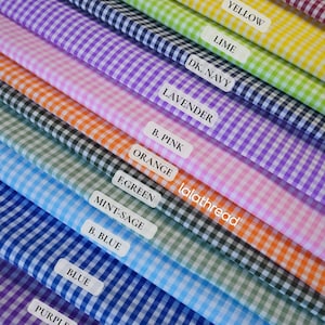 Puede incluir: Muestras de tela de cuadros vichy en varios colores, como rojo, amarillo y morado. Cada muestra est&aacute; etiquetada con su nombre de color. Tambi&eacute;n se ve el nombre de la marca "lalathread".