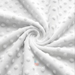 May include: A close-up shot of a white fabric with a textured, raised dot pattern. The material is arranged in a swirl, creating a spiral effect. The logo "lalathread" is visible.