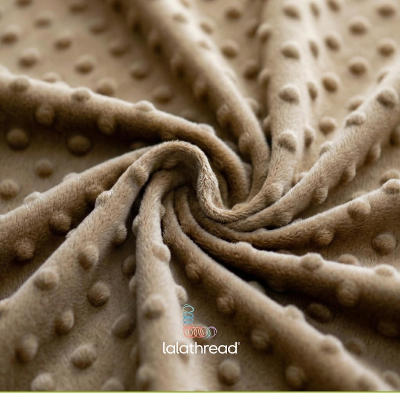 May include: A close-up shot of a beige fabric with a raised dot pattern. The material has a soft, velvety texture and a warm hue. The brand name "lalathread" is displayed in the bottom right corner.