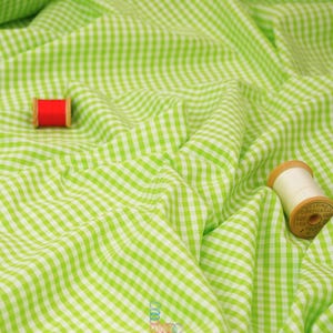 May include: Bright green and white gingham fabric with a wavy texture. Two spools of thread, one red and one cream-colored, are placed on the fabric. The fabric has the text "lalathread" in the bottom right corner.