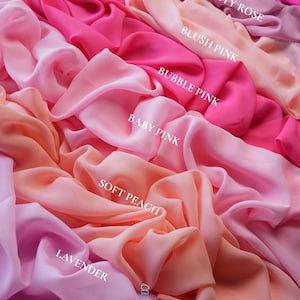 K&ouml;nnte beinhalten: Eine Auswahl an Stoffen in verschiedenen Rosa-, Pfirsich- und Lavendelt&ouml;nen. Das Bild zeigt flie&szlig;ende Textilien mit Etiketten, die Farben wie "Fuchsia", "Staubrose" und "Soft Peach" angeben. Das "lalathread"-Logo ist unten sichtbar.