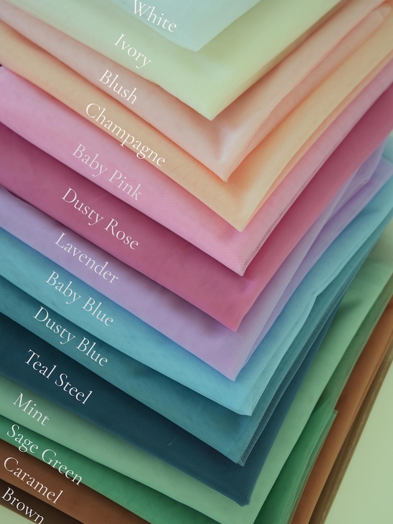 May include: A layered display of tulle fabric swatches in various colors. The colors include white, ivory, blush, champagne, baby pink, dusty rose, lavender, baby blue, dusty blue, teal steel, mint, sage green, caramel, and brown.
