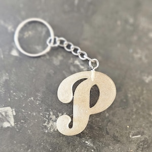 May include: A silver keychain with a sparkly gold letter P charm.