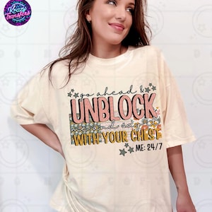 Könnte beinhalten: Cremefarbenes T-Shirt mit dem Text "go ahead & UNBLOCK me and say it WITH YOUR CHEST ME: 24/7" in einem farbenfrohen Design. Das Shirt hat kurze Ärmel und eine lockere Passform. Das Markenlogo ist oben links sichtbar.