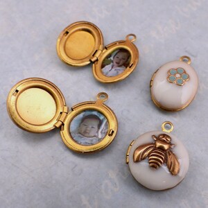 May include: Four gold-toned locket pendants with different designs. One locket has a photo of a baby, another has a photo of a child, one has a blue flower design, and the last one has a bee design.