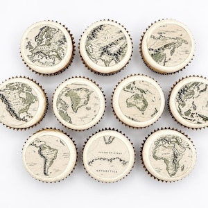 Può includere: Un set di undici cupcake rotondi, ognuno sormontato da un disco circolare commestibile che presenta una dettagliata illustrazione cartografica in stile vintage di diversi continenti e regioni, tra cui Nord America, Sud America, Europa, Asia e Antartide.