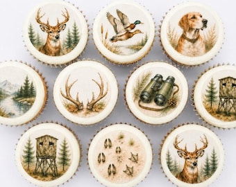 May include: A collection of decorated cupcakes with hunting-themed images. The cupcakes feature illustrations of a deer, a duck in flight, a hunting dog, binoculars, a hunting blind, deer tracks, and a landscape scene.