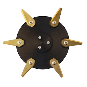 May include: A circular black base featuring six evenly spaced, pointed gold-colored metal blades attached with silver screws. The center of the black disc contains three additional silver screws arranged in a small triangle pattern.
