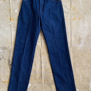Puede incluir: Un par de pantalones vaqueros de mezclilla azul oscuro con un corte recto.