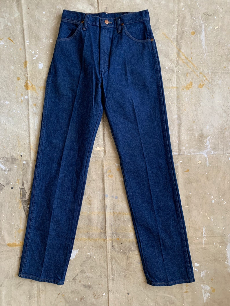Puede incluir: Un par de pantalones vaqueros de mezclilla azul oscuro con un corte recto.