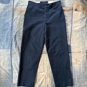 Puede incluir: Un pantalón azul oscuro de pierna recta y cierre de botón.