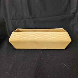 以下が含まれることがあります： 縁に波模様のある長方形の薄い黄色のセラミックプランター