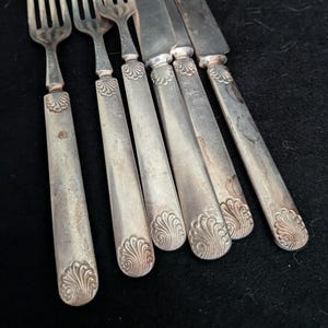Antik uppsättning av August Loch and Company silverpläterade silverbestick med snäckmotiv