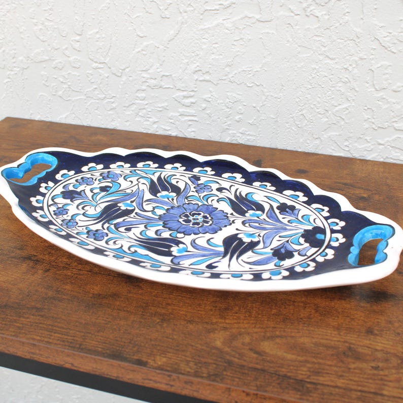 Low angle of ceramic tray resting on tabletop, showing depth and detailed flower artwork.