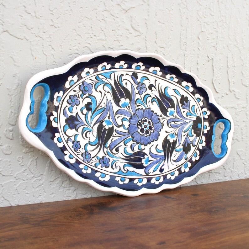 Side view of handpainted ceramic serving tray highlighting its curved edge and floral design.