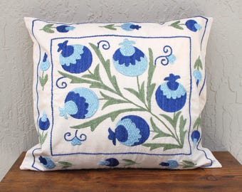 May include: White cotton pillow cover with blue and green embroidered floral design. The design features stylized flowers with blue and green leaves.