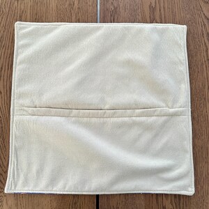 Puede incluir: Una funda de almohada blanca lisa con una costura en el centro. La funda de almohada est&aacute; hecha de una tela suave y mullida.