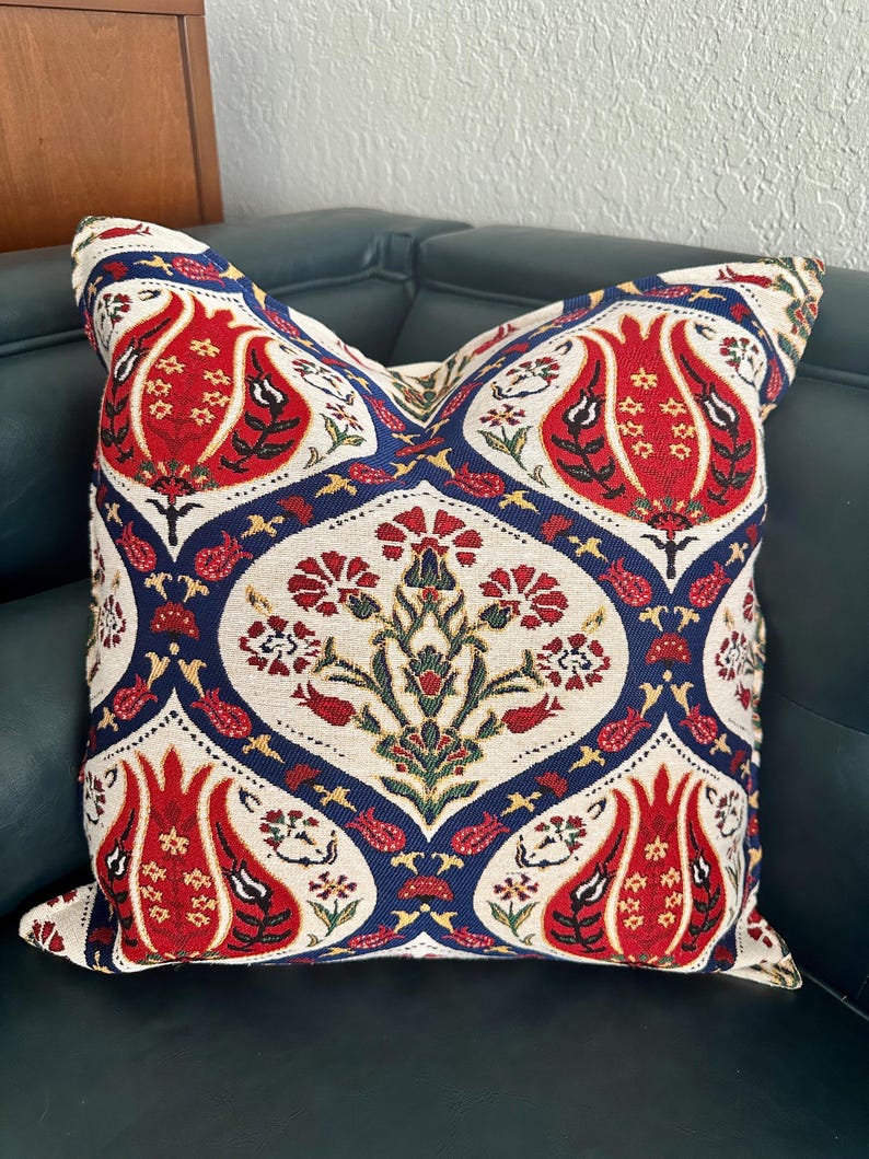 Puede incluir: Una almohada decorativa con un dise&ntilde;o tradicional turco en colores rojo, blanco, azul y verde. La almohada tiene un patr&oacute;n floral con tulipanes estilizados y otros motivos florales.