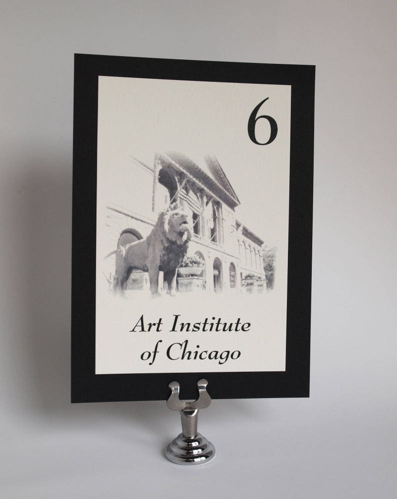 May include: Black and white photo of the Art Institute of Chicago with the lion statues in front. The table number is 6.