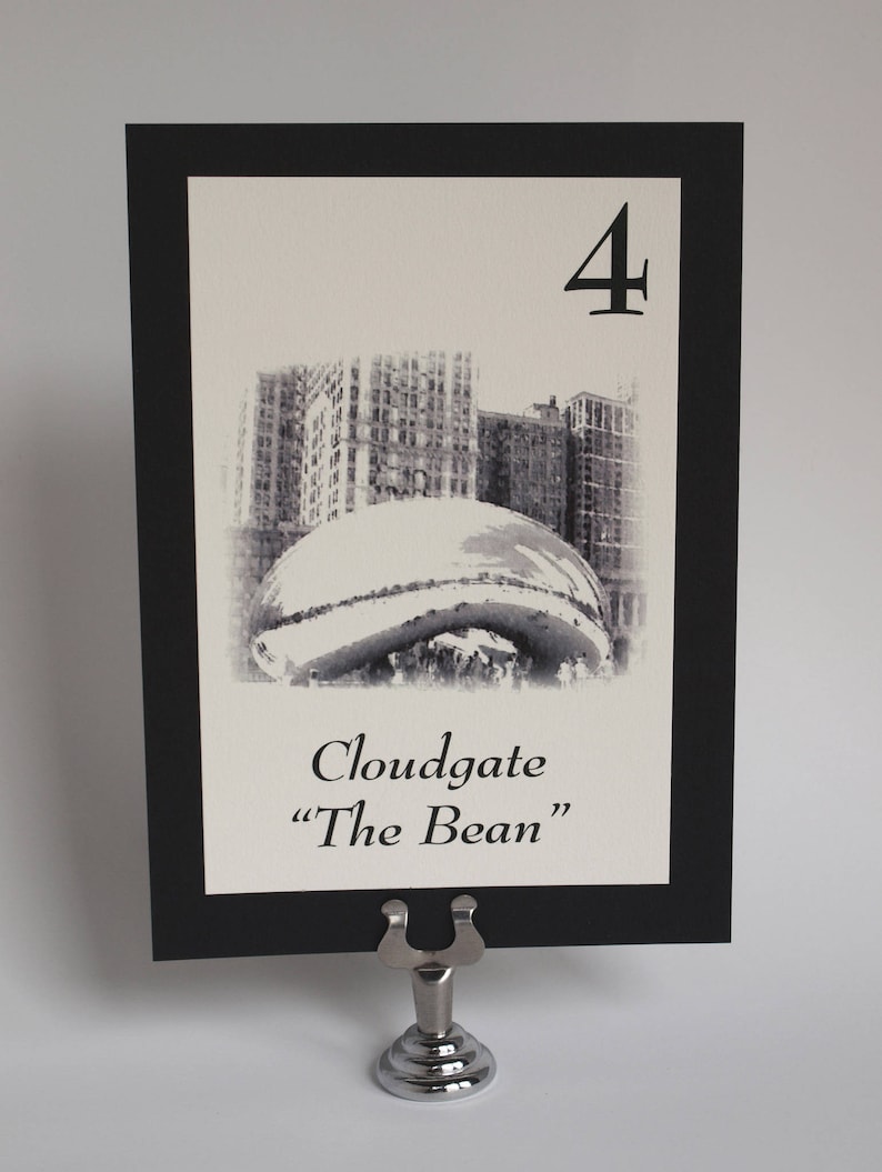 May include: Black and white table number card with a black border. The card features a photo of Cloudgate, also known as "The Bean", a public sculpture in Chicago. The number "4" is printed in the top right corner of the card.
