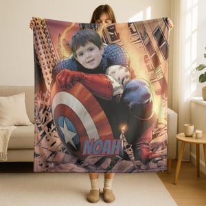 May include: A personalized Captain America blanket featuring a child's face superimposed on the superhero's body. The blanket showcases Captain America's shield and costume, with the name "NOAH" in blue. The background depicts a city scene.