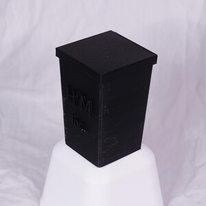 May include: A black, square-shaped box with the text "HTML" printed on the side.