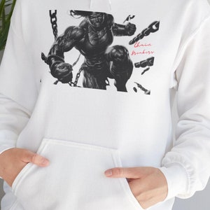 May include: White hoodie featuring a black and white illustration of a muscular figure breaking chains. The image includes the text "Chain Breakers" in red script. The hoodie has a front pocket and a drawstring hood.
