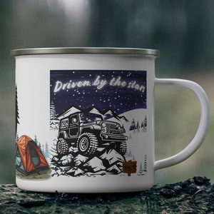 May include: White enamel camping mug with a black and white illustration of a jeep on a rocky terrain under a starry night sky. The mug also features a tent and the text "Driven by the stars". The mug has a silver rim and a white handle.