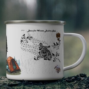 May include: White enamel camping mug with a silver rim. The mug features a graphic of a snowmobiler, a tent, and the text "Born for Winter, Built to Ride." The design includes birds and falling snow, suggesting a winter theme.