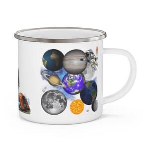 May include: White enamel mug featuring a colorful illustration of planets, the sun, and the moon. An astronaut with a rocket floats near Jupiter. The mug also has a camping scene on the side.