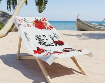 May include: A white beach chair with a printed design featuring red and black floral and koi fish illustrations. The chair is made of light-coloured wood and is set on a sandy beach with a boat in the background.