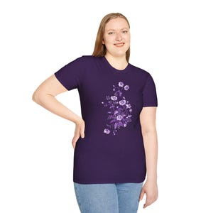 Puede incluir: Una camiseta morada con un diseño floral con flores y hojas moradas.