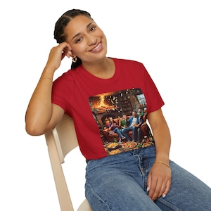Könnte beinhalten: Ein rotes T-Shirt mit einem farbenfrohen Grafikdesign, das eine Gruppe von Menschen zeigt, die Pizza und Getränke vor einem Kamin genießen. Die Grafik ist detailliert und lebendig, mit einer gemütlichen, einladenden Atmosphäre. Das Shirt besteht aus einem weichen Material.