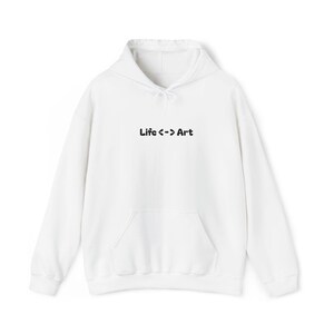 May include: White hoodie with a front pocket and drawstring hood. The text "Life <-> Art" is printed in black across the chest. The hoodie is a casual garment.