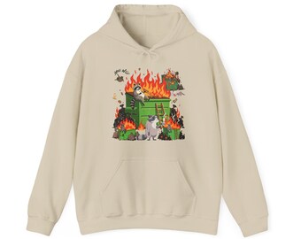 Puede incluir: Sudadera con capucha beige con un gráfico frontal de una escena de incendio de contenedor de basura. El gráfico presenta mapaches, llamas y las palabras "Hell Will". La sudadera tiene un bolsillo tipo canguro y una capucha con cordón.