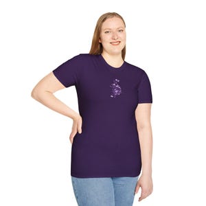 Peut inclure: Un t-shirt à manches courtes de couleur violette avec un petit motif floral sur le devant.