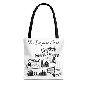 Puede incluir: Bolso tote blanco con asas negras. Presenta un diseño gráfico negro de los monumentos de Nueva York y el texto "The Empire State" y "New York Est 1788". El diseño incluye un ciervo, un granero y la palabra "Broadway".