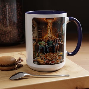 Könnte beinhalten: Weißer Keramikbecher mit marineblauem Innenraum und Griff. Der Becher zeigt eine farbenfrohe Illustration von Menschen, die eine feurige Explosion in einem Raum voller Essen und Getränke betrachten. Ein lustiges Geschenk.