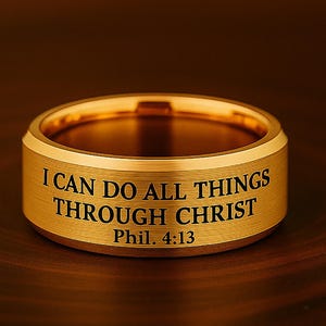 Op de afbeelding: Een gouden ring met de inscriptie "Ik kan alles door Christus Phil. 4:13".